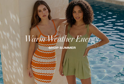 Two women posing by a swimming pool in summer fashion; one in an orange and white stripe crochet keyhole maxi dress and the other in an olive green linen romper.