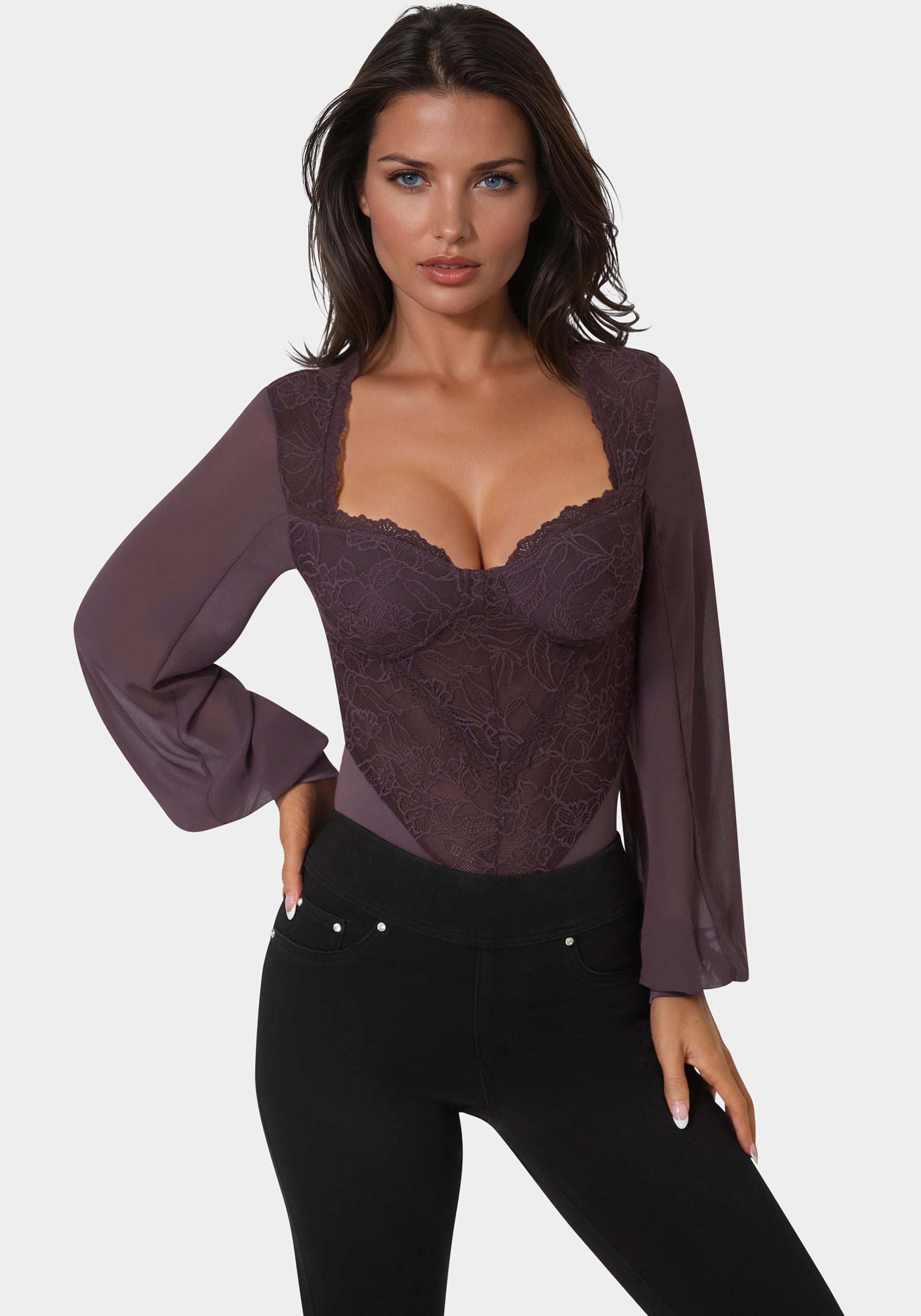 Woman wearing a dark purple blouse with long sleeves on a white background