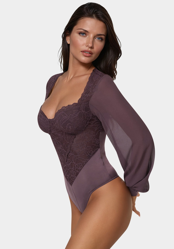 Woman wearing a sheer purple lace bodysuit on a white background