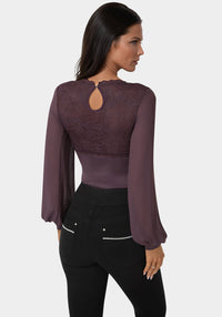 Woman wearing a purple blouse with a cut-out back design on a white background