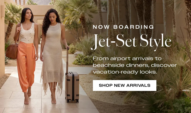 Two women walking with a suitcase down a palm tree lined path, showcasing resort-style summer fashion by bebe. Promotional text reads 'Now Boarding Jet-Set Style From airport arrivals to beachside dinners, these styles handle every plan'. CTA reads 'shop new arrivals'.