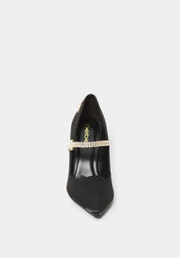 Black high-heeled shoe with a decorative band on a light gray background